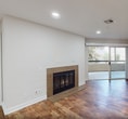 This contemporary 1030 square foot residence, located at address D115, offers a thoughtfully designed single-floor layout. The space boasts three distinct living areas, providing ample room for relaxation and entertainment. Two well-appointed bathrooms ensure convenience and privacy.

The heart of the home is a modern kitchen, featuring crisp white cabinetry, stainless steel appliances, and ample counter space. Large windows in the kitchen allow natural light to flood the space, creating a bright and airy atmosphere.

Throughout the residence, rich hardwood flooring adds warmth and elegance, contrasting beautifully with the clean white walls. Recessed lighting throughout enhances the modern aesthetic while providing adjustable illumination.

Multiple living areas showcase sliding glass doors, offering seamless indoor-outdoor flow and access to private balconies or patios. One living space includes a cozy fireplace, perfect for chilly evenings.

The laundry room is equipped with full-sized washer and dryer units, complemented by overhead storage cabinets for organization. Additional storage is available in the dedicated closet space.

The bathrooms feature sleek vanities with ample storage and modern fixtures. The overall design prioritizes functionality without compromising on style, creating a harmonious and inviting living environment.