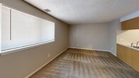 Located at 507 E. Marion Rd in Wichita, Kansas, this one-bedroom, one-bathroom apartment offers a practical and well-organized single-floor layout. The combined kitchen and living area serves as the heart of the unit, featuring warm-toned oak cabinetry, a peninsula countertop with an integrated sink, and white appliances including a refrigerator and range. Light hardwood-style flooring runs through the kitchen, transitioning to carpet in the living area, which is brightened by a large window fitted with blinds. The textured ceilings carry throughout the unit, adding a consistent architectural detail to each room. The bedroom is a comfortable, carpeted space featuring two side-by-side sliding closets that provide ample storage, along with a window that brings in natural light. An additional carpeted room with a window and direct entry door offers flexible use as a living or dining space. The bathroom includes a full tub and shower combination with a handheld showerhead, a toilet, and an overhead storage cabinet, keeping the space neat and functional. Neutral wall tones in warm beige and soft gray create a calm, cohesive atmosphere throughout the unit, making it a practical and move-in-ready home.