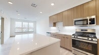 Located at 308 NJ-31 in Flemington, NJ, this thoughtfully designed one-bedroom, one-bathroom residence offers a clean, contemporary aesthetic across a efficiently laid-out single floor. Light hardwood flooring flows throughout the space, complementing the bright white walls and modern finishes.

The open-concept kitchen is a standout feature, showcasing warm wood cabinetry, white quartz countertops, a classic subway tile backsplash, and a full suite of stainless steel appliances including a gas range, dishwasher, microwave, and French door refrigerator. A central kitchen island provides additional prep and seating space, seamlessly connecting to the living area.

The living room benefits from a large window that fills the space with natural light and offers outdoor views. The bedroom is comfortably sized, featuring an expansive multi-pane window with open views, light hardwood floors, and clean white walls, creating a calm and airy retreat. A dedicated closet provides organized storage.

The bathroom is finished in a modern style with large-format floor tile, a wood-toned vanity with white countertop, a framed mirror, and chrome fixtures. A hallway connects the rooms efficiently, and an in-unit stacked washer and dryer adds everyday convenience. Recessed lighting throughout enhances the space's bright, polished atmosphere.