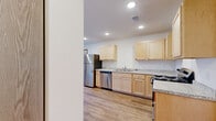 Located at 1820 Huntington Park Dr in Reedsburg, Wisconsin, this well-appointed 2-bedroom, 2-bathroom residence offers a thoughtfully designed single-floor layout with a clean, contemporary aesthetic throughout. Light-toned hardwood-style flooring runs seamlessly across every room, complementing the bright white walls and warm wood baseboards that define the interior.

The kitchen and living room share an open, connected layout. The kitchen is equipped with light maple cabinetry, granite-patterned countertops, stainless steel appliances including a range and dishwasher, and recessed lighting overhead. The adjacent living area is generously sized and filled with natural light from a large window and a sliding glass door that opens to a private balcony, offering views of the surrounding community and green landscaping.

Both bedrooms are comfortably proportioned, with the primary bedroom featuring notable floor space and a dedicated walk-in closet outfitted with built-in shelving and hanging rods. Each bathroom mirrors the kitchen's design language, featuring light wood vanities, granite-patterned countertops, and large mirrors. The consistent finishes throughout create a cohesive and practical living environment ideal for everyday comfort.