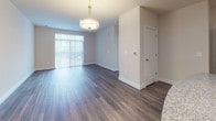 Located at 2470 Merchant Ave in Frederick, Maryland, this single-floor residence offers a thoughtfully designed layout with contemporary finishes and a cohesive aesthetic throughout. The kitchen is a standout feature, showcasing rich dark cabinetry with sleek hardware, granite countertops, a classic subway tile backsplash, and a full suite of stainless steel appliances including a refrigerator, range, and built-in microwave. A center island with pendant lighting and built-in outlets adds both functionality and style, while durable wood-look flooring ties the space together. The open living and dining area extends naturally from the kitchen, bathed in natural light from large sliding glass doors fitted with vertical blinds. An elegant pendant light fixture anchors the dining space, complementing the warm, neutral tones of the walls and flooring. The bedrooms offer plush wall-to-wall carpeting, generous closet space, and large windows that invite abundant natural light. The bathroom features large-format white tile flooring, dark cabinetry with ample storage, and a clean white countertop, maintaining the consistent contrast palette found throughout the home. Overall, the space presents a modern, move-in-ready environment with a polished and practical design.