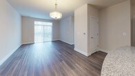 Located at 2470 Merchant Ave in Frederick, Maryland, this single-floor residence offers a thoughtfully designed layout with contemporary finishes and a cohesive aesthetic throughout. The kitchen is a standout feature, showcasing rich dark cabinetry with sleek hardware, granite countertops, a classic subway tile backsplash, and a full suite of stainless steel appliances including a refrigerator, range, and built-in microwave. A center island with pendant lighting and built-in outlets adds both functionality and style, while durable wood-look flooring ties the space together. The open living and dining area extends naturally from the kitchen, bathed in natural light from large sliding glass doors fitted with vertical blinds. An elegant pendant light fixture anchors the dining space, complementing the warm, neutral tones of the walls and flooring. The bedrooms offer plush wall-to-wall carpeting, generous closet space, and large windows that invite abundant natural light. The bathroom features large-format white tile flooring, dark cabinetry with ample storage, and a clean white countertop, maintaining the consistent contrast palette found throughout the home. Overall, the space presents a modern, move-in-ready environment with a polished and practical design.