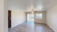 This single-floor, 3-bedroom, 1-bathroom unit offers a practical and well-organized layout across a compact but functional footprint. The living room serves as the heart of the home, featuring durable wood-look flooring, a textured ceiling, and a ceiling fan with a light fixture. Two windows and a sliding glass door with vertical blinds lead to a private balcony, allowing natural light to fill the space and offering outdoor views.

The kitchen is positioned adjacent to the living area and is outfitted with white cabinetry and stainless steel appliances, providing a clean and functional workspace. A hallway connects the living areas to the three bedrooms, each finished with the same wood-look flooring, neutral-toned walls, and ceiling fans. The primary bedroom is a generous size and includes a built-in closet with bi-fold doors and a window for natural light. The two additional bedrooms are similarly appointed, each with a window and ceiling fan.

The single full bathroom features a combined tub and shower, a vanity with white cabinetry, and matching flooring consistent with the rest of the unit. Clean, neutral finishes throughout create a cohesive and move-in-ready environment.