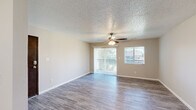 This single-floor, 3-bedroom, 1-bathroom unit offers a practical and well-organized layout across a compact but functional footprint. The living room serves as the heart of the home, featuring durable wood-look flooring, a textured ceiling, and a ceiling fan with a light fixture. Two windows and a sliding glass door with vertical blinds lead to a private balcony, allowing natural light to fill the space and offering outdoor views.

The kitchen is positioned adjacent to the living area and is outfitted with white cabinetry and stainless steel appliances, providing a clean and functional workspace. A hallway connects the living areas to the three bedrooms, each finished with the same wood-look flooring, neutral-toned walls, and ceiling fans. The primary bedroom is a generous size and includes a built-in closet with bi-fold doors and a window for natural light. The two additional bedrooms are similarly appointed, each with a window and ceiling fan.

The single full bathroom features a combined tub and shower, a vanity with white cabinetry, and matching flooring consistent with the rest of the unit. Clean, neutral finishes throughout create a cohesive and move-in-ready environment.