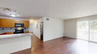 Located at 1124 Clinton Avenue in Saint Clair, Michigan, this single-floor, 3-bedroom, 1-bathroom unit offers a well-designed layout with consistent finishes throughout. Rich hardwood flooring flows across the open-concept living and kitchen area, creating a cohesive and inviting atmosphere. The kitchen is thoughtfully appointed with warm honey-toned cabinetry, granite countertops, a tile backsplash, and black appliances including a range, microwave, and stainless steel refrigerator. A peninsula counter separates the kitchen from the living area, offering a functional transition between the two spaces. The spacious living room receives generous natural light through a sliding glass door that opens onto a private balcony with outdoor views. The primary bedroom is comfortably sized and includes closet storage. The two additional bedrooms feature hardwood floors and windows that bring in natural light. The bathroom is finished with a granite-topped vanity, warm wood cabinetry, and a large mirror. Additional storage is provided by two closets, and a hallway connects the main living spaces to the bedrooms. The unit's clean, neutral palette and quality finishes make for a comfortable and functional living environment.