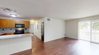 Located at 1124 Clinton Avenue in Saint Clair, Michigan, this single-floor, 3-bedroom, 1-bathroom unit offers a well-designed layout with consistent finishes throughout. Rich hardwood flooring flows across the open-concept living and kitchen area, creating a cohesive and inviting atmosphere. The kitchen is thoughtfully appointed with warm honey-toned cabinetry, granite countertops, a tile backsplash, and black appliances including a range, microwave, and stainless steel refrigerator. A peninsula counter separates the kitchen from the living area, offering a functional transition between the two spaces. The spacious living room receives generous natural light through a sliding glass door that opens onto a private balcony with outdoor views. The primary bedroom is comfortably sized and includes closet storage. The two additional bedrooms feature hardwood floors and windows that bring in natural light. The bathroom is finished with a granite-topped vanity, warm wood cabinetry, and a large mirror. Additional storage is provided by two closets, and a hallway connects the main living spaces to the bedrooms. The unit's clean, neutral palette and quality finishes make for a comfortable and functional living environment.