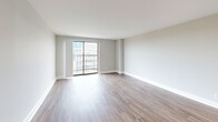 Located at 120 E Main Street in the heart of downtown Lexington, KY, this one-bedroom, one-bathroom unit offers a well-designed layout across a single floor. Wood-style plank flooring runs throughout the entire space, lending warmth and visual continuity to every room.

The open-concept kitchen and living area serves as the heart of the unit. The kitchen is outfitted with dark espresso cabinetry, light granite-style countertops, a classic white subway tile backsplash, and a full suite of stainless steel appliances including a range, microwave, and refrigerator. A peninsula with an integrated sink provides additional workspace and casual seating potential. The spacious living room opens directly to a private balcony through a sliding glass door, filling the space with natural light and offering outdoor views of the surrounding cityscape.

The bedroom is a well-proportioned retreat featuring soft gray walls, a large closet with paneled double doors, and a window that brings in additional natural light. Recessed lighting throughout the unit ensures consistent, clean illumination.

The bathroom features dark vanity cabinetry with a light countertop, a full tub/shower combo with built-in shelving, recessed ceiling lighting, and the same wood-style flooring carried throughout the unit, creating a cohesive and modern aesthetic.