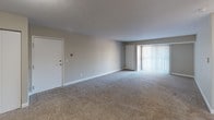 Located at 307 E Lasalle Ave in South Bend, Indiana, this single-floor unit offers a well-organized layout designed for comfortable everyday living. The galley-style kitchen is a standout feature, outfitted with dark espresso cabinetry, speckled granite-look countertops, and stainless steel appliances including a range, built-in microwave, and refrigerator. Warm wood-look flooring runs throughout the kitchen, adding contrast to the dark cabinetry and neutral walls. The kitchen flows directly into the main living area, which is generously proportioned and finished with wall-to-wall carpeting and soft, neutral-toned walls. A sliding glass door with vertical blinds fills the living space with natural light and provides exterior access. The bedroom is a quiet, carpeted retreat featuring a window with blinds that overlooks the surrounding neighborhood, allowing for natural light. The full bathroom is clean and functional, featuring a tub/shower combination with a chrome fixtures, a single-sink vanity with a framed mirror, and bright overhead lighting. The unit also includes in-unit laundry connections. Throughout the space, consistent neutral tones, clean lines, and practical finishes create a cohesive and move-in-ready environment.