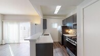 Located at 3324 Castle Heights Ave in Los Angeles, CA, this single-floor unit offers a thoughtfully updated interior with a clean, modern aesthetic throughout. The open-concept layout connects the living area to the kitchen, creating a seamless flow ideal for everyday living and entertaining.

The kitchen is a standout feature, equipped with stainless steel appliances including a gas range, built-in microwave, and refrigerator. Dark espresso cabinetry reaches to the ceiling, providing ample storage, while a white quartz peninsula countertop with an integrated sink serves as both a functional workspace and a visual divider between the kitchen and living areas. A skylight overhead and a small window bring in natural light, and wood-look flooring ties the space together with warmth and continuity.

The living room is generously proportioned, featuring the same hardwood-style flooring and large sliding glass doors that flood the space with natural light and provide outdoor access. A charming arched architectural detail accents the hallway leading to the bedroom, which includes mirrored sliding closet doors that enhance the sense of space.

The bathroom is cleanly finished with a vessel sink atop a dark vanity, a large wall mirror, and a full bathtub with shower. Overall, the unit presents a cohesive, contemporary design with practical finishes throughout.