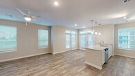 Located in Gulf Shores, Alabama, this well-appointed 2-bedroom, 2-bathroom single-floor residence offers a thoughtfully designed open-concept layout. The living and dining area is bright and airy, featuring wood-look plank flooring, recessed lighting, a ceiling fan, and multiple windows with French door access that invite abundant natural light. The kitchen is a functional centerpiece, showcasing white shaker-style cabinetry, a subway tile backsplash, light countertops, stainless steel appliances including a range, built-in microwave, dishwasher, and a French door refrigerator. A kitchen island with pendant lighting and a sink adds both style and practicality. The hallway connects the main living areas to the bedrooms, each with carpeted flooring and closet space. The bathrooms are clean and neutral, with one featuring hexagonal tile flooring, a vanity with ample counter space, and a tiled shower. A dedicated laundry room with washer and dryer hookups provides added convenience. The consistent warm-neutral color palette and modern finishes create a cohesive, move-in-ready atmosphere throughout this Gulf Shores residence.