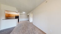 This single-floor, 2-bedroom, 2-bathroom residence offers a functional and comfortable layout designed for everyday living. The open living area features neutral-toned carpet and clean white walls, creating a bright and inviting atmosphere. A hallway connects the main living space to the bedrooms and bathrooms, ensuring a logical and efficient flow throughout.

The kitchen is well-equipped with warm honey-toned wood cabinetry, dark granite-style countertops, and black appliances including a range, dishwasher, and refrigerator. Wood-look flooring adds a grounded, practical feel to this space, which also benefits from a window providing natural light.

The primary bedroom is generously sized, featuring plush carpet, a ceiling fan, and two windows that invite ample natural light and outdoor views. It is complemented by a spacious walk-in closet outfitted with wire shelving systems on three walls, offering substantial storage capacity. The second bedroom is comfortably sized with soft carpet and clean white walls.

Both bathrooms are finished with warm wood-toned vanities, white countertops, full soaking tubs with showers, and wood-look flooring. The overall design of this residence is clean, neutral, and move-in ready, with consistent finishes throughout that lend a cohesive and tidy aesthetic.