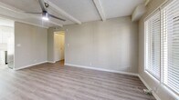 This two-bedroom, two-bathroom residence in Phoenix, Arizona offers a well-designed single-level layout with consistent light wood-tone luxury vinyl plank flooring throughout. The open living room serves as the heart of the home, featuring exposed beam detailing on the textured ceiling, a modern ceiling fan, and a large window that allows natural light to fill the space. A front entry door with sidelights adds to the bright, welcoming atmosphere.

The kitchen is thoughtfully updated with crisp white shaker cabinetry, light quartz countertops, a white subway tile backsplash, and a full suite of stainless steel appliances including a range, microwave, and dishwasher. A window above the sink provides additional natural light.

Both bedrooms are comfortably sized with neutral wall tones, textured ceilings, ceiling fans, and windows with blinds. The primary bedroom includes a louvered closet door. Each bedroom benefits from a calm, functional layout suited for everyday living.

The two bathrooms offer distinct configurations: one features a sliding-door enclosed shower with chrome hardware, while the second includes a full tub-shower combination with a curved rod. Both are finished with clean, neutral materials and wood-tone flooring. A hallway and dedicated closet complete this efficient and move-in ready home.