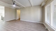 This two-bedroom, two-bathroom residence in Phoenix, Arizona offers a well-designed single-level layout with consistent light wood-tone luxury vinyl plank flooring throughout. The open living room serves as the heart of the home, featuring exposed beam detailing on the textured ceiling, a modern ceiling fan, and a large window that allows natural light to fill the space. A front entry door with sidelights adds to the bright, welcoming atmosphere.

The kitchen is thoughtfully updated with crisp white shaker cabinetry, light quartz countertops, a white subway tile backsplash, and a full suite of stainless steel appliances including a range, microwave, and dishwasher. A window above the sink provides additional natural light.

Both bedrooms are comfortably sized with neutral wall tones, textured ceilings, ceiling fans, and windows with blinds. The primary bedroom includes a louvered closet door. Each bedroom benefits from a calm, functional layout suited for everyday living.

The two bathrooms offer distinct configurations: one features a sliding-door enclosed shower with chrome hardware, while the second includes a full tub-shower combination with a curved rod. Both are finished with clean, neutral materials and wood-tone flooring. A hallway and dedicated closet complete this efficient and move-in ready home.
