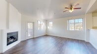 Located in Pleasanton, CA (94566), this single-story unit offers a clean, modern interior with a cohesive design throughout. The open living area serves as the heart of the space, characterized by wide-plank wood-style flooring, crisp white walls, and abundant natural light streaming through multiple windows. A ceiling fan with an integrated light fixture overhead adds both function and a classic touch. A private exterior door provides convenient direct access to the outdoors.

A hallway with matching wood-style flooring connects the main living area to the remaining rooms. The kitchen is well-appointed with ample white cabinetry, light countertops, and stainless steel appliances including an electric range and an over-the-range microwave, all complemented by the same durable flooring found throughout the common areas.

The bedroom is carpeted for added comfort and features multiple windows that invite natural light and outdoor views. Two bathrooms are present in the unit, each finished with wood-style flooring, white vanities with light countertops, and chrome hardware and grab bars, reflecting a practical and accessible design. Overall, the space presents a bright, well-maintained environment with consistent finishes throughout.
