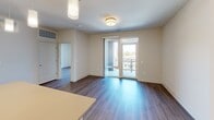 Located at 610 Park Rd NW in Washington, DC's vibrant 20010 corridor, this single-floor unit offers a thoughtfully designed layout that maximizes its compact footprint. The open-concept living area features warm hardwood-style flooring and neutral walls that create a bright, welcoming ambiance. Glass French doors lead to a private balcony, filling the living space with natural light and offering views of the surrounding neighborhood.

The kitchen is a standout feature, showcasing white shaker cabinetry with sleek hardware, a bold tile backsplash, and a full suite of stainless steel appliances including a refrigerator, range, dishwasher, and microwave. Warm-toned countertops and a central island with pendant lighting provide both functionality and style, while the hardwood-style flooring ties the kitchen seamlessly into the main living area.

The bathroom is well-appointed with large-format dark tile flooring, a combination tub and shower with subway tile surround, a white vanity with under-cabinet storage, and a modern rounded mirror with overhead lighting.

A dedicated laundry area houses a stacked full-size washer and dryer unit, adding practical convenience. The overall design reflects a clean, modern aesthetic with consistent finishes throughout.
