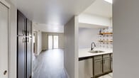 Located at 1829 E Morten Ave in Phoenix, AZ, this single-floor, 2-bedroom, 4-bathroom residence offers a thoughtfully designed layout with contemporary finishes throughout. The open-concept living area features wood-look plank flooring in a soft gray tone, neutral-painted walls, and a textured ceiling, creating a bright and welcoming atmosphere. Sliding glass doors lead to a private patio, allowing natural light to fill the space. The kitchen is a functional highlight, featuring stainless steel appliances — including a refrigerator, range, and built-in microwave — white upper cabinetry, gray lower cabinets, a skylight, and a peninsula with a sleek white countertop and undermount sink. Open shelving with warm wood accents adds a modern touch. Both bedrooms are carpeted for comfort, with neutral tones and ample natural light from windows with blinds. The primary bedroom includes a sliding-door closet and additional storage. The bathrooms are clean and minimal, featuring white tub-shower combinations, wood-look tile flooring, and vanities with white countertops and dark hardware. Three closets and two hallways contribute to practical storage and efficient flow throughout. The overall ambiance is clean, modern, and move-in ready.