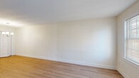 Located at 604 Devils Foot Rd in North Kingstown, Rhode Island, this single-floor, two-bedroom, one-bathroom unit offers a clean and functional layout with a cohesive, modern aesthetic throughout. Light hardwood flooring runs continuously across the living spaces, complementing the crisp white walls and white trim that give the home a bright, open feel.

The living room is a welcoming entry point into the unit, featuring a paneled exterior door with sidelight windows that allow natural light to filter in. The kitchen is well-appointed with white shaker-style cabinetry, marble-look countertops, a stainless steel single-basin sink, and modern appliances including a stainless steel range. The layout makes efficient use of the space available.

The primary bedroom features a chandelier-style light fixture and a closet, while the second bedroom benefits from a large window framing views of the surrounding wooded landscape, along with a wall-mounted AC unit and baseboard heating. Both rooms are finished with the same warm hardwood flooring. The bathroom area includes built-in wire shelving for storage and access to an additional closet with wire-rack organization.

Throughout the unit, the neutral color palette, consistent flooring, and natural light create a calm, livable atmosphere suited for everyday comfort.