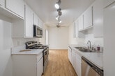 Located at 3711 W 230th St in Torrance, CA, this single-floor unit offers a clean, functional layout with a bright and neutral aesthetic throughout. The living area is finished with warm hardwood flooring and features a large sliding glass door that opens to a private balcony, filling the space with natural light and providing open views of the surrounding neighborhood.

The galley-style kitchen is well-appointed with white cabinetry, light countertops, a stainless steel sink, and stainless steel appliances including a range and microwave. Track lighting overhead keeps the space bright and practical.

The bedrooms are carpeted for comfort and feature vertical blind-covered windows that allow for adjustable natural light. One bedroom includes direct access to the bathroom and a walk-in closet, offering added convenience and storage.

A hallway with hardwood flooring connects the main areas of the unit, leading to the full bathroom. The bathroom is finished with a white vanity, quartz-style countertop, a large mirror with overhead lighting, and a tub and shower combination enclosed by sliding frosted glass doors. Hardwood flooring extends into the bathroom, adding a cohesive touch. Textured ceilings are present throughout, complementing the overall clean, move-in-ready condition of the space.