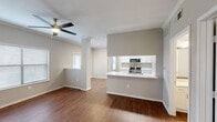 Located in Fort Worth, TX, this well-appointed 2-bedroom, 2-bathroom residence offers a thoughtfully designed single-floor layout. The open-concept living and dining area is anchored by rich hardwood-style flooring and a ceiling fan, creating a comfortable, airy atmosphere. A pass-through kitchen features white cabinetry, gleaming white countertops, stainless steel appliances — including a refrigerator, electric range, microwave, and dishwasher — and a deep undermount sink, making it both functional and visually clean. Natural light fills the space through multiple windows and a glass patio door that opens to outdoor views, adding a welcoming sense of openness. Both bedrooms are carpeted for comfort and include ceiling fans, with the primary bedroom offering a generous footprint and its own closet with wire shelving for organized storage. A second walk-in style closet provides additional storage. Each bathroom is equipped with a tub-shower combo, white tile surround, and wood-tone flooring, with one bathroom featuring a white vanity with updated hardware and a framed mirror. The neutral color palette throughout the home creates a cohesive, move-in-ready environment suited for everyday living.