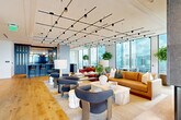 Located in the heart of Midtown Atlanta, this elegantly appointed high-rise amenity space offers a seamless blend of modern design and upscale comfort. The open-plan layout is anchored by wide-plank hardwood flooring and floor-to-ceiling glass walls that frame sweeping panoramic views of the Atlanta skyline, flooding the interior with abundant natural light throughout the day.

The main lounge area is thoughtfully arranged with multiple curated seating vignettes, featuring a mix of leather sofas, bouclé accent chairs, and sculptural stone side tables beneath a striking geometric track lighting system. Lush indoor trees punctuate the space, adding warmth and a biophilic element to the contemporary aesthetic.

A dedicated wet bar and kitchen area showcases deep navy cabinetry, a large island with bar seating, and pendant globe lighting, providing a refined service hub for entertaining. Adjacent to the lounge, an intimate dining room is defined by a dramatic floor-to-ceiling diagonal wine rack wall, a rich walnut oval table, and an artistic pendant chandelier, creating a striking private dining experience.

Two expansive outdoor terraces extend the living space outward, furnished with lounge chairs and dining sets against an unobstructed backdrop of Atlanta's iconic skyline—offering an exceptional setting for both relaxation and social gatherings.