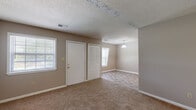 Located at 3111 S Leonard Springs Rd in Bloomington, Indiana, this single-floor unit offers three bedrooms, one bathroom, and one kitchen within a compact, efficiently arranged floor plan. The bedrooms are carpeted throughout, with neutral-toned walls and textured ceilings that contribute to a simple, understated aesthetic. Each bedroom includes closet storage — some featuring bifold doors — and windows that allow natural light to filter in. The generously sized primary bedroom offers ample floor space and a full closet with a hanging rod. The kitchen is equipped with white cabinetry, white countertops, a gas range, a dishwasher, and a double-basin sink, all set atop durable tile-style flooring that extends into the bathroom. The bathroom is clean and functional, featuring a tub-shower combination, a toilet, and a vanity with warm wood-toned cabinetry. Throughout the unit, clean white trim and baseboards frame each room. The overall layout, as seen in the dollhouse view, reflects a straightforward, connected floor plan that maximizes the use of available space, making this unit a practical and accessible option in the Bloomington area.