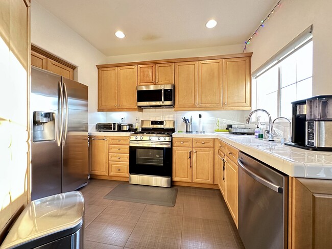 Kitchen equipped with LG refrigerator, dishwasher, microwave, & gas stove - 1583 W Katella Ave