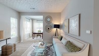 Located at 7703 Lee Rd in Lithia Springs, Georgia, this thoughtfully designed single-floor residence offers a cohesive open layout with a warm, contemporary aesthetic throughout. The living area serves as the heart of the home, featuring plush carpeting, a decorative textured ceiling, and natural light streaming through multiple windows dressed with sheer white curtains. The space flows seamlessly into a den or office area, providing a flexible room well-suited for work or leisure.

The kitchen is well-appointed with white upper cabinetry, gray lower cabinets, stainless steel appliances, a classic subway tile backsplash, and granite-style countertops that extend to a breakfast bar with seating. Adjacent to the kitchen, a dedicated dining nook features wood-look flooring, wainscoting, and recessed lighting, creating an inviting space for meals.

The bedrooms are comfortably sized with plush carpeting, ample natural light from large windows, and ceiling fans for added comfort. The bathrooms are clean and functional, featuring wood-look tile flooring, granite-topped vanities, and a tub-shower combination. Throughout the home, a soft gray color palette, recessed lighting, and consistent finishes contribute to a polished, move-in-ready atmosphere.