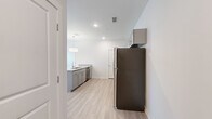 This thoughtfully designed 2-bedroom, 2-bathroom residence offers a comfortable and functional single-floor layout. The open-concept kitchen and living area serves as the heart of the home, anchored by a large central island with a granite countertop, undermount sink, and pendant lighting overhead. Gray shaker-style cabinetry lines the kitchen walls, complemented by matching granite countertops, stainless steel appliances, and light hardwood-style flooring that extends throughout the main living areas.

The living area opens to an outdoor access point, flanked by large windows fitted with horizontal blinds that invite generous natural light and offer views of the surrounding greenery. Both bedrooms feature soft carpeted flooring and are well-sized, with the primary bedroom providing a comfortable retreat. Each bedroom includes access to a closet for ample storage.

The two bathrooms maintain a consistent, clean aesthetic. One features a granite-topped vanity with gray cabinetry and a large mirror, while the other includes a full soaking tub with tiled surround and chrome fixtures. Throughout the residence, crisp white walls, recessed lighting, and a neutral palette create a bright, modern ambiance suited for everyday living.