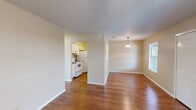 This 2-bedroom, 1-bathroom home at Crossings offers a well-organized single-level layout designed for comfortable everyday living. Warm hardwood-style flooring flows consistently throughout the main living areas and bedrooms, creating a cohesive and inviting atmosphere. The open living and dining area is bright and airy, featuring a ceiling fan and natural light from a window overlooking the surroundings. A pendant light fixture anchors the dedicated dining space, which connects seamlessly to the kitchen. The kitchen is efficiently laid out with white cabinetry, a refrigerator, and a range, providing all essential appliances in a compact and functional space. Sliding glass doors in one of the bedrooms open to a private balcony, offering outdoor views and additional ventilation. Both bedrooms are well-proportioned, each equipped with ceiling fans and ample natural light. The primary bedroom is a comfortable size and includes access to a dedicated closet with built-in shelving and hanging rods. The full bathroom features a combined tub and shower, a single vanity with cabinet storage, a mirrored medicine cabinet, and light tile flooring. Textured ceilings are consistent throughout the home, adding a classic finishing detail to each room.