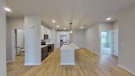 This single-story residence in Elgin, IL offers 1,790 square feet of living space, including four bedrooms and two bathrooms. The home's layout is thoughtfully designed, with a generously sized primary bedroom of 490 square feet. The kitchen is a standout feature, boasting modern white cabinetry, stainless steel appliances, and a large center island with a sleek sink. A striking rectangular light fixture adds a contemporary touch to the space.

The flooring throughout the home varies, with warm-toned hardwood in the main living areas and kitchen, and plush carpeting in some bedrooms. Large windows in the bedrooms allow for ample natural light, while providing views of the surrounding area. The bathrooms are well-appointed, featuring both a traditional tub-shower combo and a modern glass-enclosed shower, complemented by dark fixtures for a stylish contrast.

The home's neutral color palette, primarily in shades of white and light gray, creates a clean and bright atmosphere throughout. Recessed lighting and carefully placed fixtures ensure well-lit spaces. An attached garage provides convenient parking and storage options. Overall, this property offers a blend of modern amenities and comfortable living spaces, suitable for a variety of lifestyles.