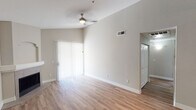 Located at 204 E Fillmore St in Phoenix, Arizona, this single-floor residence offers a thoughtfully designed layout with a variety of functional and stylish living spaces. The open-concept living area features soaring vaulted ceilings, a ceiling fan, and a tiled fireplace, creating an airy and inviting atmosphere. Light wood-look flooring flows throughout the main living areas, while sliding glass doors allow natural light to pour in and provide outdoor access. The kitchen is a standout feature, showcasing dark cabinetry, granite countertops, a breakfast bar peninsula, and a full suite of stainless steel appliances including a refrigerator, range, and built-in microwave. A built-in shelving nook adjacent to the kitchen adds practical storage and display space. The bedrooms are carpeted for comfort, with the primary bedroom boasting dramatic vaulted ceilings, a bay window, and direct access to an en-suite bathroom featuring dark vanity cabinetry, granite counters, and a shower/tub combination. Additional bathrooms are clean and well-appointed with tub/shower combos and wood-look flooring. The neutral color palette throughout lends the space a modern, move-in-ready appeal.