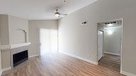 Located at 204 E Fillmore St in Phoenix, Arizona, this single-floor residence offers a thoughtfully designed layout with a variety of functional and stylish living spaces. The open-concept living area features soaring vaulted ceilings, a ceiling fan, and a tiled fireplace, creating an airy and inviting atmosphere. Light wood-look flooring flows throughout the main living areas, while sliding glass doors allow natural light to pour in and provide outdoor access. The kitchen is a standout feature, showcasing dark cabinetry, granite countertops, a breakfast bar peninsula, and a full suite of stainless steel appliances including a refrigerator, range, and built-in microwave. A built-in shelving nook adjacent to the kitchen adds practical storage and display space. The bedrooms are carpeted for comfort, with the primary bedroom boasting dramatic vaulted ceilings, a bay window, and direct access to an en-suite bathroom featuring dark vanity cabinetry, granite counters, and a shower/tub combination. Additional bathrooms are clean and well-appointed with tub/shower combos and wood-look flooring. The neutral color palette throughout lends the space a modern, move-in-ready appeal.