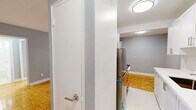 Located at 35 Spencer Ave in Toronto's vibrant Parkdale neighbourhood, this one-bedroom, one-bathroom unit offers a well-organized layout across a single floor. Warm-toned parquet flooring flows throughout the living spaces, adding timeless character to the soft grey-painted walls.

The combined kitchen and living area is thoughtfully divided. The galley-style kitchen features crisp white shaker cabinetry with brushed nickel hardware, white quartz countertops, a stainless steel refrigerator, and a gas range — offering ample storage and a clean, functional workspace. The adjoining living room is bright and open, with a large window and direct access to a private balcony, allowing for natural light and outdoor views.

The bedroom is a comfortable size, featuring a built-in sliding closet, a window with natural light, and the same polished parquet flooring seen throughout. Radiator heating units are present in both the living room and bedroom, characteristic of the building's classic construction.

The bathroom is finished in clean white tile, complete with a full soaker tub and a window above, providing ventilation and natural light. A dedicated entrance area completes this practical and well-maintained unit, making it a solid choice in central Toronto.