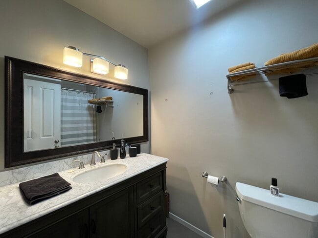 Full bathroom with large vanity, storage, and shower/tub combo. - 1591 Ellis St