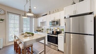 Located at 5885 Lakehurst Dr in Orlando, FL, this thoughtfully designed one-bedroom, one-bathroom residence offers a well-utilized layout with stylish modern finishes throughout. The open-concept kitchen is a standout feature, showcasing white shaker cabinetry extending to the ceiling, granite countertops, a classic subway tile backsplash, and a full suite of stainless steel appliances. Pendant lighting over the central island/bar seating area adds warmth, while a large window fills the space with natural light. The living room is bright and welcoming, featuring wood-look flooring, a ceiling fan, and large windows with views of the outdoors. The bedroom is a comfortable retreat with plush carpeting, dual windows for natural light, and a ceiling fan. It is complemented by a dedicated walk-in closet with wire shelving for organized storage. The bathroom impresses with a large walk-in shower clad in marble-style tile, a rainfall showerhead, and granite vanity countertops, delivering a clean, spa-like aesthetic. Wood-look flooring flows throughout the main living areas, tying the space together with a cohesive, contemporary feel.