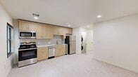 Located at 101 N Broadway Ave in the heart of Oklahoma City, this 2-bedroom, 1-bathroom unit offers a thoughtfully designed single-floor layout. The combined kitchen and living area serves as the central hub of the space, featuring light wood cabinetry, a subway tile backsplash, stainless steel appliances including a gas range, dishwasher, and refrigerator, and recessed lighting throughout. A stacked washer and dryer unit is conveniently tucked nearby, adding everyday practicality. Light-toned flooring runs throughout the unit, lending a clean and cohesive aesthetic.

The two bedrooms are well-proportioned and finished in neutral tones, each equipped with a ceiling fan for year-round comfort. The primary bedroom includes a double-door closet, while an additional window in the secondary bedroom allows natural light and urban views. With a total of four closets across the unit, storage is abundant.

The bathroom stands out with its marble-style tiled tub surround, classic hexagonal mosaic floor tiles, and warm brass fixtures — a refined touch that elevates the overall design. A bright, clean hallway connects the rooms, and an entrance area provides a welcoming transition into the home. The crisp white walls and consistent finishes create a modern, move-in-ready environment.