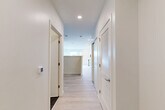 Located at 46 Soldiers Field Place in Boston, MA, this thoughtfully designed single-floor unit offers a clean, contemporary aesthetic throughout. Light-toned hardwood flooring runs continuously across the space, complementing the crisp white walls and recessed lighting that keep the interior bright and welcoming.

A wide hallway entrance provides access to the various areas of the unit, with louvered closet doors offering convenient built-in storage. The open-concept layout seamlessly integrates the kitchen, dining, and living areas into one cohesive space. The kitchen is outfitted with tall white shaker cabinetry, a full suite of stainless steel appliances including a refrigerator, range, microwave, and dishwasher, and a light-toned countertop. A large window in the living and kitchen area floods the space with natural light and offers views of the surrounding Boston neighborhood.

The bathroom features a sleek, modern design with large-format dark tile flooring, a glass-enclosed walk-in shower finished with classic white subway tile, and a floating vanity with a white countertop and a frameless mirror above. In-unit laundry adds a practical convenience, while two dedicated closets provide ample storage throughout the home.
