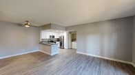 This 3-bedroom, 3-bathroom unit is thoughtfully designed with a clean, contemporary aesthetic throughout. The open-concept kitchen and living room serve as the heart of the space, featuring light wood-look flooring, neutral gray walls, and a textured ceiling. The kitchen is well-equipped with stainless steel appliances — including a range, microwave, and refrigerator — complemented by crisp white cabinetry, dark countertops, and a peninsula with sink that doubles as a breakfast bar. Recessed lighting illuminates the kitchen, while an adjacent alcove houses a full-size washer and dryer for added convenience. Each of the three bedrooms offers a calm, functional retreat with light flooring, neutral walls, and windows fitted with vertical blinds that allow for natural light. The primary bedroom includes sliding glass doors that open directly to a private balcony with outdoor views. The three bathrooms are clean and functional; one features a large wall mirror, soft vanity lighting, and an undermount sink with neutral countertops, while another includes a full tub-shower combination. A hallway connects the rooms, supporting a practical and efficient floor plan. Throughout the unit, the consistent use of light tones and modern finishes creates a cohesive and welcoming atmosphere.