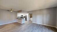 This 3-bedroom, 3-bathroom unit is thoughtfully designed with a clean, contemporary aesthetic throughout. The open-concept kitchen and living room serve as the heart of the space, featuring light wood-look flooring, neutral gray walls, and a textured ceiling. The kitchen is well-equipped with stainless steel appliances — including a range, microwave, and refrigerator — complemented by crisp white cabinetry, dark countertops, and a peninsula with sink that doubles as a breakfast bar. Recessed lighting illuminates the kitchen, while an adjacent alcove houses a full-size washer and dryer for added convenience. Each of the three bedrooms offers a calm, functional retreat with light flooring, neutral walls, and windows fitted with vertical blinds that allow for natural light. The primary bedroom includes sliding glass doors that open directly to a private balcony with outdoor views. The three bathrooms are clean and functional; one features a large wall mirror, soft vanity lighting, and an undermount sink with neutral countertops, while another includes a full tub-shower combination. A hallway connects the rooms, supporting a practical and efficient floor plan. Throughout the unit, the consistent use of light tones and modern finishes creates a cohesive and welcoming atmosphere.