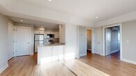 Located at 925 Mix Ave in Hamden, Connecticut, this well-appointed one-bedroom, one-bathroom unit offers a thoughtfully designed open-concept layout finished with light hardwood flooring throughout. The living area is bright and airy, bathed in natural light through large windows that frame outdoor views of the surrounding neighborhood and treeline, creating a welcoming and comfortable atmosphere.

The kitchen is a standout feature, equipped with a full suite of stainless steel appliances including a refrigerator, electric range, built-in microwave, and dishwasher. Crisp white shaker cabinetry with brushed nickel hardware pairs elegantly with granite-style countertops, and a peninsula provides added prep space and a natural division between the kitchen and living area.

The bedroom is a comfortable, well-proportioned space featuring a large window with expansive outdoor views, recessed lighting, and generous wall space. The bathroom is finished with a white shaker-style vanity, quartz countertop, a framed mirror, and hardwood-style flooring that ties seamlessly into the rest of the unit. Neutral gray walls, recessed lighting, and clean white trim contribute to the space's modern, move-in-ready aesthetic throughout.