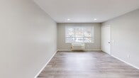 Located at 1700 RT 37 W in Toms River, NJ, this single-floor, one-bedroom, one-bathroom unit offers a thoughtfully designed layout that maximizes functionality. Light-toned luxury vinyl plank flooring flows consistently throughout the space, lending a clean, cohesive aesthetic to every room.

The open-concept living, dining, and kitchen area serves as the heart of the home. The kitchen is well-appointed with crisp white shaker cabinetry, marble-look countertops, white appliances including a gas range and refrigerator, and an in-unit washer — all illuminated by a flush skylight-style ceiling fixture and a window that brings in natural light.

The bedroom features soft sage-green walls, large windows with exterior views, and two closets offering ample storage. Its generous proportions provide a comfortable and private retreat. An additional room with neutral warm-gray walls, recessed lighting, and a wall-mounted HVAC unit adds versatility to the floor plan.

The bathroom is equipped with a full soaking tub, a pedestal-style vanity with a medicine cabinet, tile flooring, and accessibility-friendly grab bars, ensuring both comfort and practicality. A dedicated entrance area completes the layout. Overall, the unit presents a clean, move-in-ready interior with a bright, neutral palette throughout.
