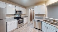 Located at 4865 Babcock Trail in Inver Grove Heights, Minnesota, this single-floor unit offers a well-organized layout designed for comfortable everyday living. The open living area is finished with light wood-style flooring and connects seamlessly to the kitchen, creating an inviting, functional flow throughout the main space. Large windows dressed with vertical blinds allow natural light to fill the living room, offering views of the surrounding outdoor landscape.

The kitchen is a standout feature, equipped with stainless steel appliances including a range, over-the-range microwave, and dishwasher. White cabinetry pairs with granite-style countertops to create a clean, contemporary aesthetic, complemented by the same light wood-style flooring that runs through the main living areas.

The bedrooms are carpeted in soft gray tones, providing a comfortable retreat. Each room benefits from natural light through windows with vertical blinds and includes baseboard heating. Textured ceilings are consistent throughout the bedrooms.

The bathroom is neatly appointed with wood-style flooring, a full tub and shower combination, a toilet, and a vanity with granite-style countertops and white cabinetry with built-in shelving. Sliding door access is available from one of the living spaces, adding outdoor connectivity to this practical and well-maintained unit.