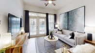 Located at 307 Karl Linn Dr in North Chesterfield, Virginia, this single-floor residence offers a thoughtfully designed open-concept layout with contemporary finishes throughout. The living area is bright and welcoming, featuring large French doors that invite abundant natural light and provide outdoor access. A ceiling fan overhead and elegant drapery framing the windows contribute to the room's polished, comfortable atmosphere.

The kitchen is a functional centerpiece of the home, equipped with rich dark-stained cabinetry, granite countertops, a stainless steel appliance suite including a refrigerator, electric range, and microwave, as well as a tile backsplash. An island with a stainless steel sink adds prep space and serves as a natural transition point between the kitchen and living areas. Light wood-style flooring runs throughout these main living spaces, adding warmth and continuity.

The bedrooms are carpeted for comfort and sized to accommodate substantial furniture. Each room benefits from large windows that bring in natural light, with the primary bedroom featuring an adjoining bathroom complete with a tiled soaking tub and shower combination. The overall aesthetic of the home is clean and modern, with neutral tones providing a versatile backdrop throughout.