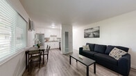 Located at 3430 Freedom Park Dr in North Highlands, CA, this efficient one-bedroom, one-bathroom unit offers a well-organized layout across a single floor. Light wood-style flooring runs throughout the entire space, creating a consistent and clean aesthetic from room to room.

The open-plan living and dining area flows directly into the kitchen, maximizing the sense of space. The living room provides a comfortable gathering area with neutral white walls and a textured ceiling. The kitchen is well-appointed with white shaker-style cabinetry, granite-look countertops, stainless steel appliances including a refrigerator and dishwasher, and a window that invites natural light.

The bedroom is a bright, well-proportioned room featuring a ceiling fan with light fixture, a large window with outdoor views, a wall-mounted air conditioning unit, and a sliding-door closet offering ample storage. The clean white walls keep the room feeling airy and open.

The bathroom is neatly finished with a white vanity, over-cabinet storage, a combined tub and shower, and a frosted window for natural light and privacy. A connecting hallway ties all rooms together efficiently. Overall, the unit presents a tidy, functional living environment with consistent modern finishes throughout.
