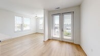 This well-appointed 2-bedroom, 2-bathroom unit at 900 N Allen Ave in Richmond, VA offers a thoughtfully designed open-concept layout with modern finishes throughout. Light hardwood flooring flows seamlessly across the living spaces, complementing the bright, neutral walls that maximize the natural light pouring in through multiple large windows.

The kitchen is a standout feature, showcasing two-tone cabinetry with crisp white upper cabinets and bold navy-blue lower cabinets and island base. Stainless steel appliances, a full-height pantry cabinet, and a quartz countertop island with an integrated sink complete the functional and stylish space.

The living area opens directly to a private balcony through elegant French doors, extending the living space outdoors with views of the surrounding Richmond neighborhood. A sliding barn door adds a contemporary architectural detail connecting rooms.

Both bedrooms are generously proportioned, each featuring ceiling fans, large windows with outdoor views, and warm hardwood flooring. The primary bedroom benefits from dedicated closet space.

The two bathrooms are finished with large-format tile flooring, sleek dark-cabinet vanities topped with white counters, framed mirrors, and modern fixtures. Accessibility features including grab bars are also present, reflecting thoughtful, inclusive design throughout this well-crafted urban residence.