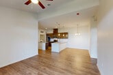 Located in Youngsville, Louisiana, this well-appointed single-story home offers three bedrooms, two bathrooms, and a thoughtfully designed open-concept layout. The heart of the home is a modern kitchen featuring rich dark-brown cabinetry, stainless steel appliances, granite countertops, and a large island with a built-in sink — all illuminated by stylish pendant lighting. The kitchen flows seamlessly into the dining and living areas, where light wood-look flooring, ceiling fans, and French doors with transom windows invite natural light and provide access to the patio. The living room is generously proportioned, offering a bright and airy atmosphere. Each bedroom is finished with plush carpeting, a ceiling fan, a window for natural light, and dedicated closet space — including walk-in closets with wire shelving. The bathrooms are clean and modern, with granite-topped vanities and a tub-shower combination. A dedicated laundry room accommodates a full-size washer and dryer. With four closets throughout, storage is plentiful. The overall design is clean and contemporary, combining functional living spaces with comfortable finishes throughout.