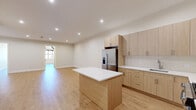 Located at 684 Main Ave in Passaic, NJ, this well-appointed 3-bedroom, 1-bathroom unit offers a thoughtfully designed layout with modern finishes throughout. Light hardwood flooring flows seamlessly across the entire space, creating a warm and cohesive aesthetic.

The kitchen is a standout feature, boasting light wood cabinetry, white quartz countertops, a subway tile backsplash, stainless steel appliances including a gas range, microwave, and French door refrigerator, as well as a center island that provides additional prep and dining space. Recessed lighting enhances the bright, clean atmosphere.

The living area is generously sized and open, illuminated by recessed ceiling lights and complemented by clean white walls. The bedrooms offer comfortable proportions, with several rooms featuring sputnik-style pendant light fixtures and windows with views of the surrounding neighborhood. The spacious primary bedroom includes exposed beam accents and vaulted ceiling details, adding architectural character.

The bathroom is finished with large-format marble-look tile flooring, a floating wood vanity, a backlit oval mirror, and modern fixtures, creating a sleek and contemporary feel. Two closets, including a built-in shelved storage closet, provide practical organization solutions throughout the unit.