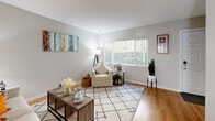 Located at 2925 Monument Blvd in Concord, California, this two-story, 3-bedroom, 3-bathroom home offers a well-organized layout split evenly across two floors. The main level features a welcoming living room with warm hardwood-style flooring, neutral gray walls, and a large window that fills the space with natural light. Adjacent to the living room, the combined dining and kitchen area is a functional highlight — the kitchen features white cabinetry, a skylight, granite-style countertops, and a pass-through bar counter that opens into the bright dining space. The dining area benefits from a full sliding glass door with vertical blinds, allowing abundant outdoor light to pour in. The bathrooms are well-appointed, featuring granite-style vanity countertops with white cabinetry and tub-shower combinations with sliding glass enclosures. Upstairs, the carpeted hallway leads to three comfortable bedrooms, including a generously sized primary bedroom. The upper level maintains the same clean, neutral aesthetic found throughout the home. Overall, the space presents a practical and inviting layout with consistent finishes, making it a comfortable and functional residence in the heart of Concord.