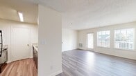 Located at 11704 Rustic View Ln in Fredericksburg, Virginia, this single-floor residence offers a thoughtfully arranged layout designed for comfortable everyday living. The open-concept living area is finished with light-toned, wood-style luxury vinyl plank flooring that extends throughout the main living and kitchen spaces, creating a cohesive and easy-to-maintain environment. Natural light flows generously into the living room through a combination of a glass exterior door and flanking windows, brightening the neutral white walls and textured ceiling. A floor-mounted HVAC vent provides efficient climate control throughout the space.

The kitchen is efficiently designed with gray cabinetry, light stone-look countertops, and stainless steel appliances including a dishwasher, offering a functional workspace that connects conveniently to the main living area via a pass-through or open partition.

The bedrooms are carpeted in a warm, neutral tone and receive natural light through standard windows, providing a comfortable and quiet retreat. The bathrooms are finished with clean, white fixtures, including a walk-in shower stall in one bathroom and a dedicated vanity area featuring dark wood cabinetry, a white countertop, and mirrored medicine cabinets, contributing to a practical and well-appointed design throughout.