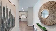 This thoughtfully designed 2-bedroom, 2-bathroom single-floor residence offers a comfortable and functional layout with modern finishes throughout. The open-concept living, dining, and kitchen area forms the heart of the home, with warm hardwood-style flooring that flows seamlessly through the main spaces. The kitchen is outfitted with light wood cabinetry, a classic white subway tile backsplash, stainless steel appliances, and recessed lighting, making it as practical as it is attractive. The adjacent dining area provides an ideal space for everyday meals or entertaining. The living room benefits from large windows dressed with patterned curtains, allowing abundant natural light to fill the space. Both bedrooms are carpeted and offer a tranquil retreat, with the primary bedroom featuring dual windows and access to a dedicated closet. The primary bathroom includes a long vanity with light wood cabinetry, a clean white countertop, and direct access to a walk-in closet with built-in shelving. A second well-sized closet provides additional storage. Soft, neutral tones and recessed lighting are consistent throughout, creating a cohesive and inviting ambiance across every room.